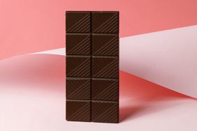 whole bar of dark chocolate on pink abstract background