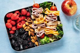 lunchbox filled with berries and a skewer style sandwich