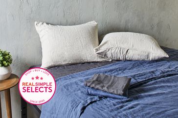 A set of one of the best linen sheets on a bed with a Real Simple Selects badge.