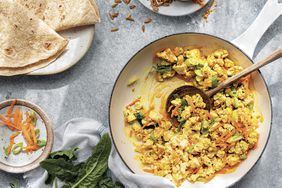 Jane Goodall's Tofu Scramble With Spinach and Spiced Sunflower Seeds Served in a Pan, Surrounded by Tortillas and More Seeds